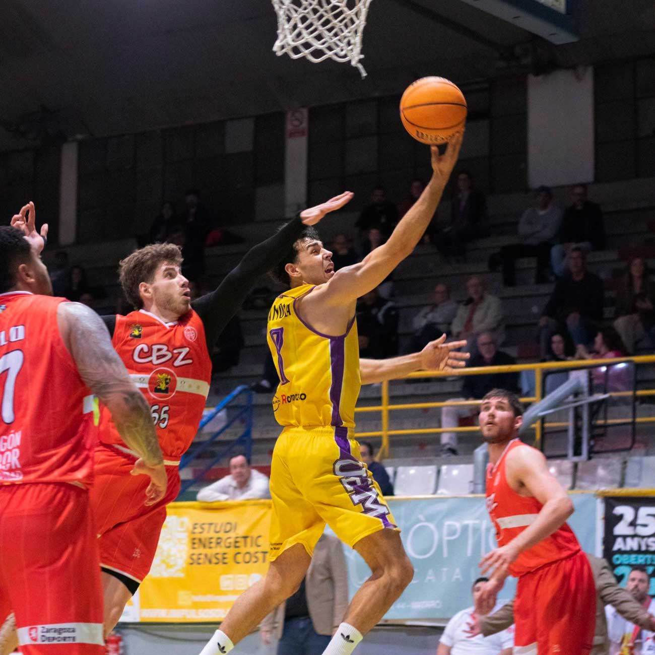 CB Mataró player finishing a layup at the basket during a match.